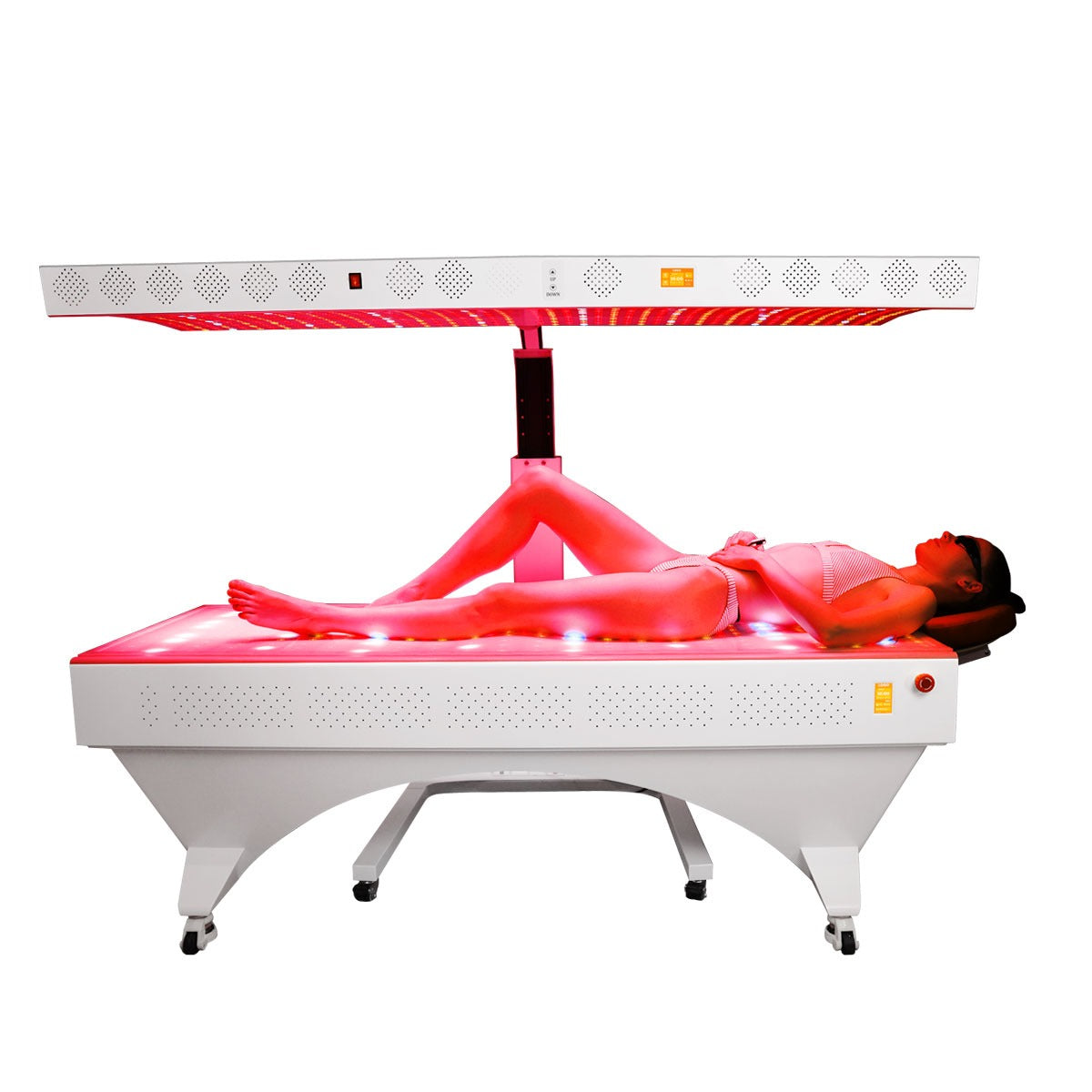 Profesjonell rødlysterapiseng med justerbart overpanel, hvit metallramme og brukeren liggende i bikini.