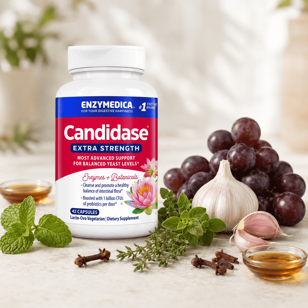 Candidase® Extra Strength kosttilskudd i hvit flaske med blå etikett, omringet av hvitløk, druer, og urter.