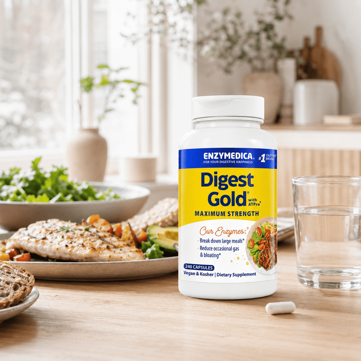 Digest Gold® med ATPro® i en hvit beholder står på et bord, omgitt av en tallerken med fisk, salat og brød.