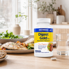 Digest Gold® med ATPro® i en hvit beholder står på et bord, omgitt av en tallerken med fisk, salat og brød.