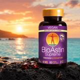 BioAstin Supreme astaxantin i en brun plastflaske med gul lokk, seks røde softgels på svart stein, horisont med solnedgang.